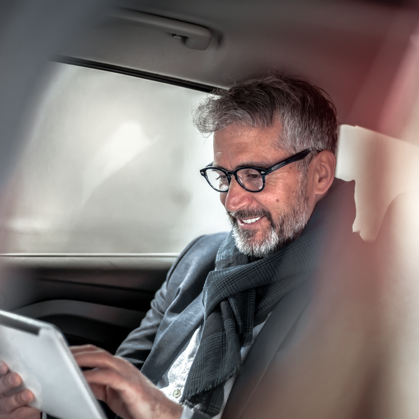 Bild eines Mannes mit einem Tablet in einem Auto